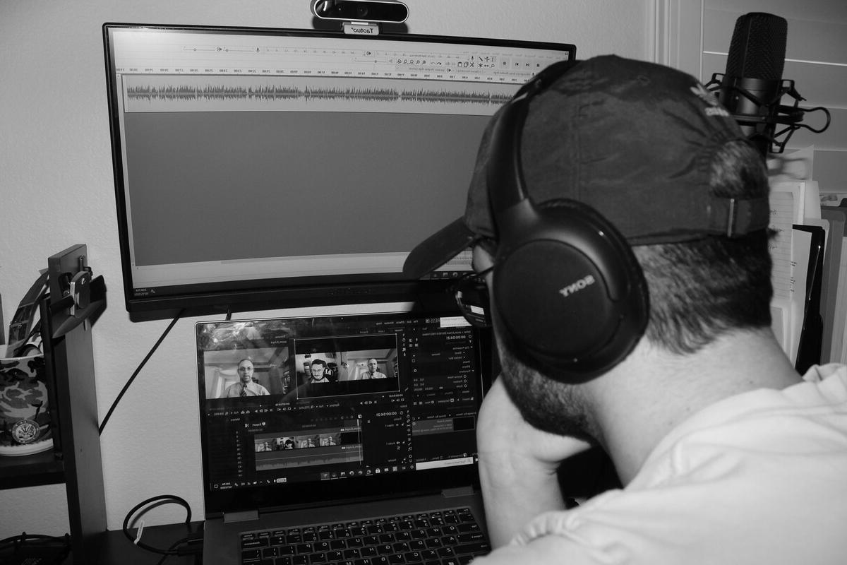 A man with headphones looking at a computer.