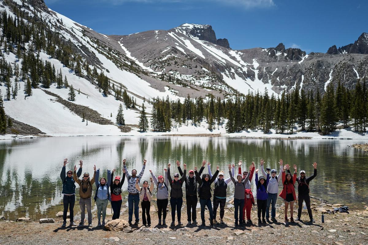 Students posing in front of snowy mountains