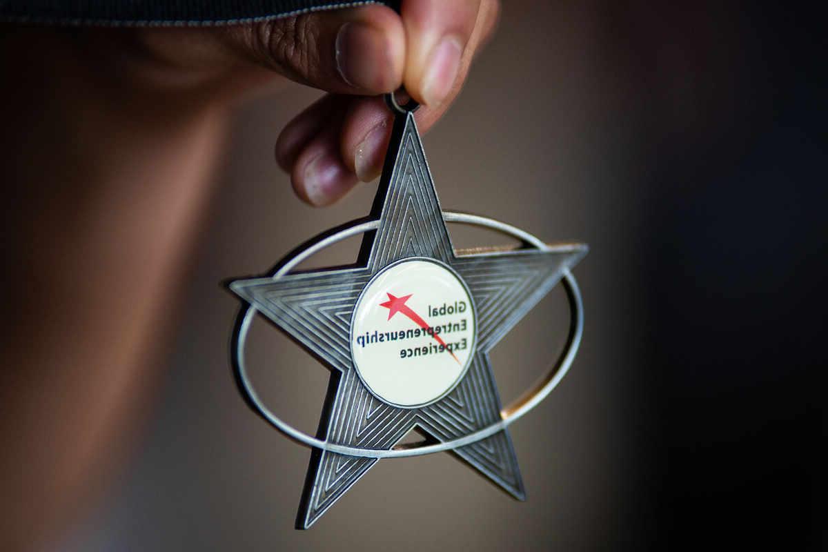 Person holding star medallion that says &”;Global Scholarship Entrepreneurship&”;
