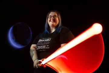 individual swinging a red light saber with a glowing photo effect