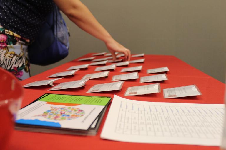 Person selecting a name badge from a table