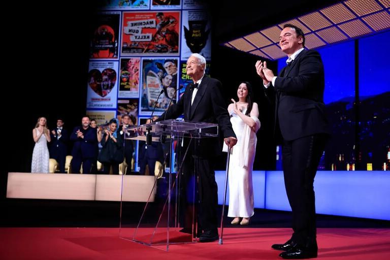 Roger Corman stands on stage with Quentin Tarantino as he arrives to award the Grand Prix during the closing ceremony of the 76th edition of the Cannes 电影 Festival.